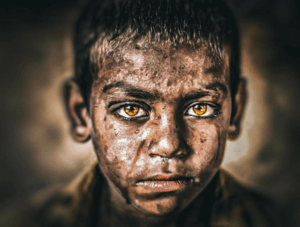 Eyes that carry the weight of struggle, yet shine with unyielding hope