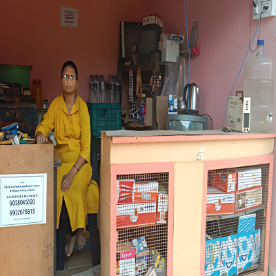 A woman with a visual disability confidently manages her small business from behind a desk in a well-organized shop.